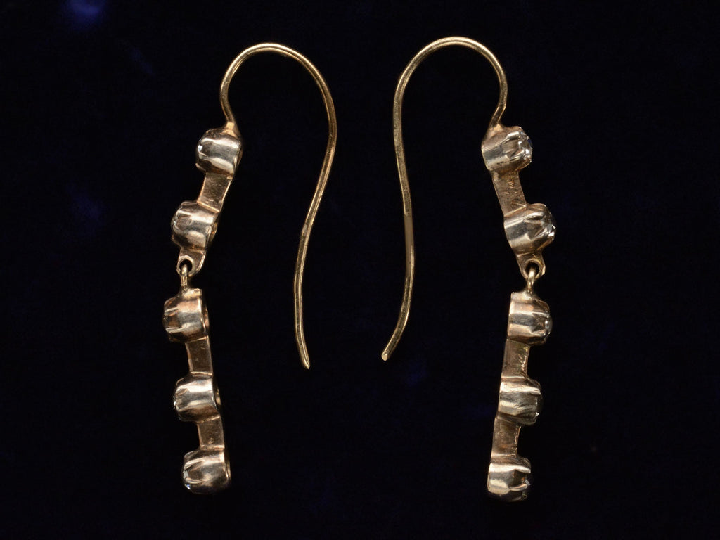 Side profile of c1900 Five Diamond Drop Earrings in Yellow Gold (on dark background)