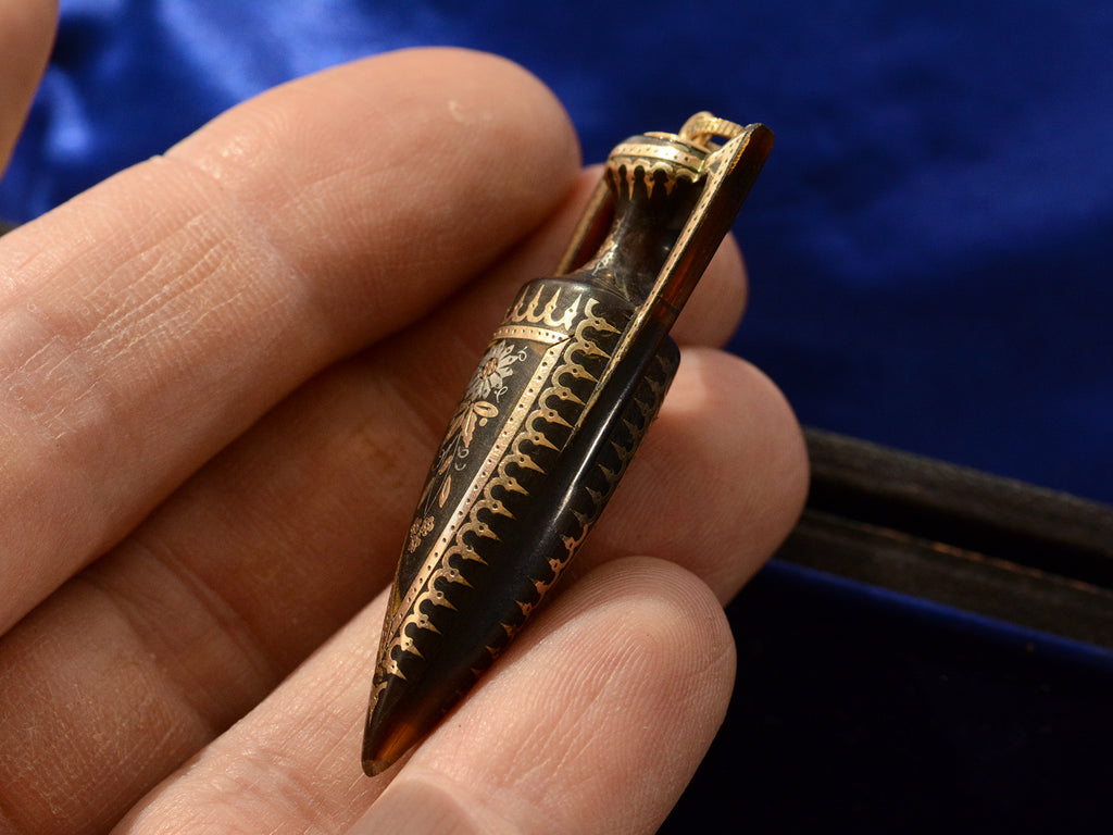 Side view of c1870 Pique Amphora Pendant (on hand for scale)