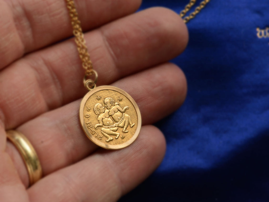 c1970 Round Yellow Gold Pendant with Gemini Twins and the numbers "21.5-21.6." (shown on hand for scale)
