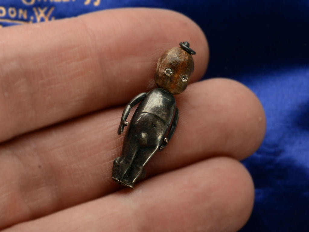 c1915 Kewpie Doll Charm with Oxidized Silver Body and Wooden Head (shown in hand for scale)