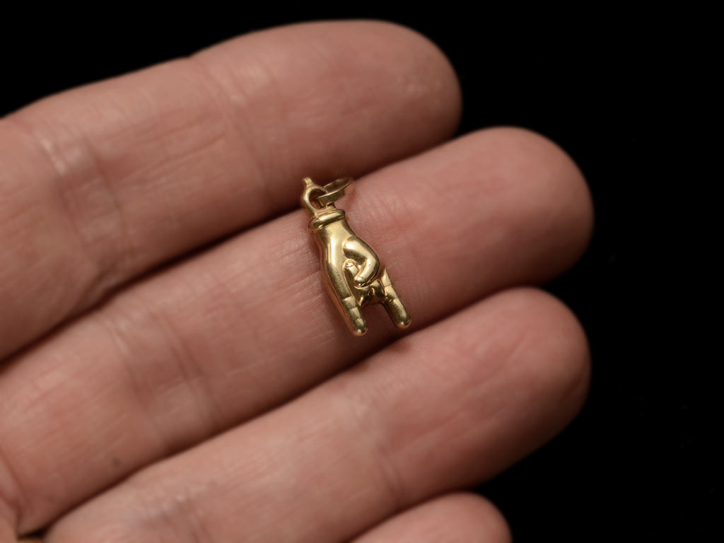 c1980 Gold Mano Cornuto Charm (on hand for scale)