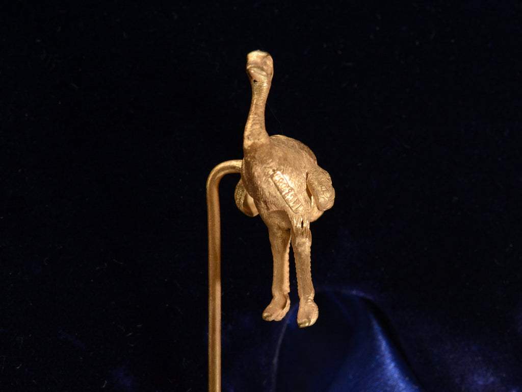 Front view of Antique yellow gold ostrich stick pin (on black background) A mark stamped "14ct 585" is visible.