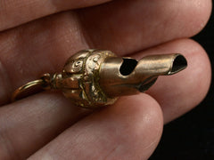 thumbnail of c1890 Gold Whistle Pendant (side view on hand for scale)