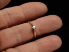 thumbnail of An antique ring with a 0.20ct old mine cut diamond set in a simple silver topped 14K yellow gold mounting, shown on finger.