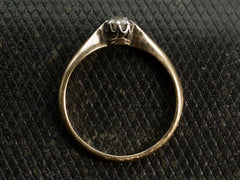 thumbnail of Side profile of an antique ring with a 0.20ct old mine cut diamond set in a simple silver topped 14K yellow gold mounting, shown on dark textured background.