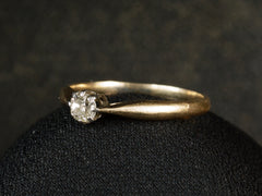thumbnail of Side view of an antique ring with a 0.20ct old mine cut diamond set in a simple silver topped 14K yellow gold mounting, shown on dark background.