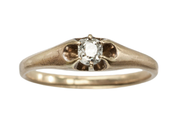 An antique rosy-yellow gold Victorian engagement ring with a small old mine cut diamond in a belcher setting. Shown on white background.
