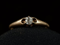 thumbnail of An antique rosy-yellow gold Victorian engagement ring with a small old mine cut diamond in a belcher setting. Shown on black background.