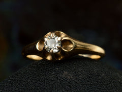 thumbnail of Right angled front view of an antique Victorian solitaire engagement ring with a round diamond set in a six pronged rosy-yellow gold belcher mounting. Shown on dark background.