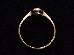 thumbnail of Side profile of an antique Edwardian era engagement ring with a round diamond in a simple silver topped rosy-yellow gold mounting, shown on black background.