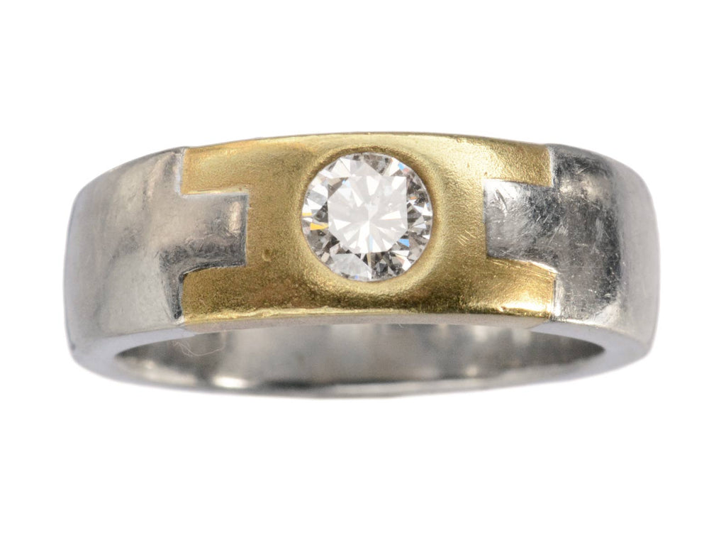 A vintage two toned platinum and yellow gold band set with a round diamond, shown on a white background.