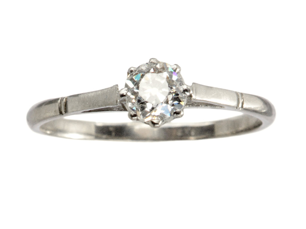 A simple 1920 solitaire engagement ring with a old European cut diamond set in 18K white gold, shown on white background.