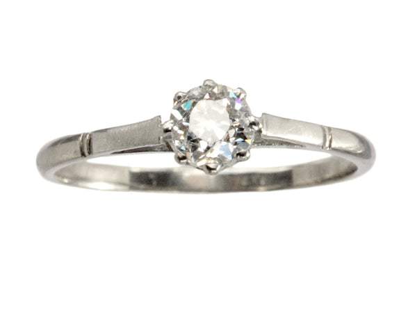 A simple 1920 solitaire engagement ring with a old European cut diamond set in 18K white gold, shown on white background.