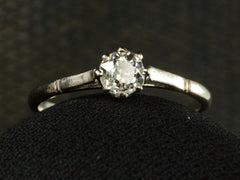 thumbnail of A simple 1920 solitaire engagement ring with a old European cut diamond set in 18K white gold, shown on dark background.