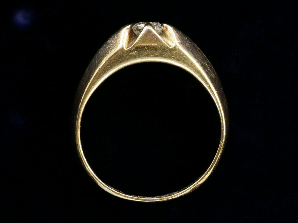 Side profile of wide antique men's ring with cushion shaped old cut white diamonds set in yellow gold, shown on dark background.