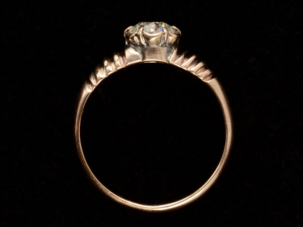 Side profile of a Victorian solitaire ring with a square old mine cut diamond set in a wide striped rose gold setting, shown on dark background.