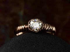 thumbnail of A Victorian solitaire ring with a square old mine cut diamond set in a wide striped rose gold setting, shown on white background.