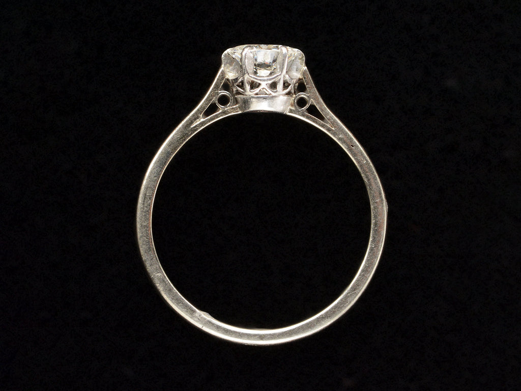 Side profile of an Art Deco white gold solitaire with a round old European cut diamond, shown on black background.