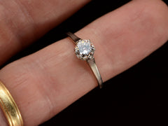 thumbnail of A simple Art Deco white gold solitaire with a round old European cut diamond, shown on finger.