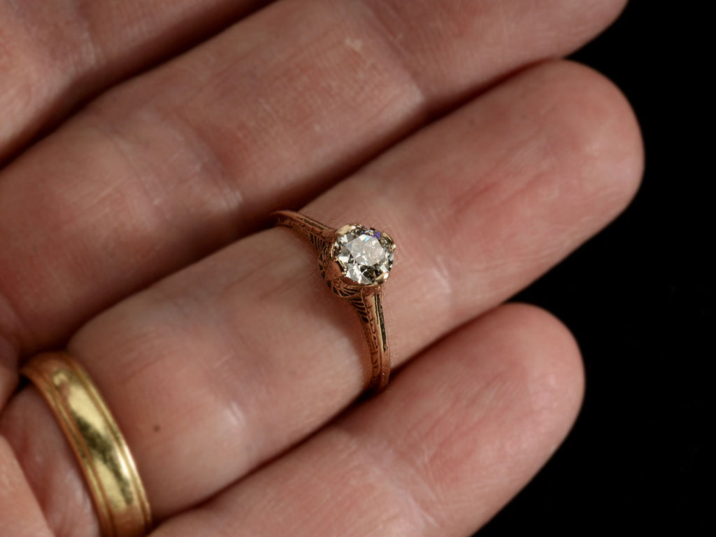 Front view of c1920 Art Deco yellow gold engagement ring with a 0.64ct round diamond (on finger)