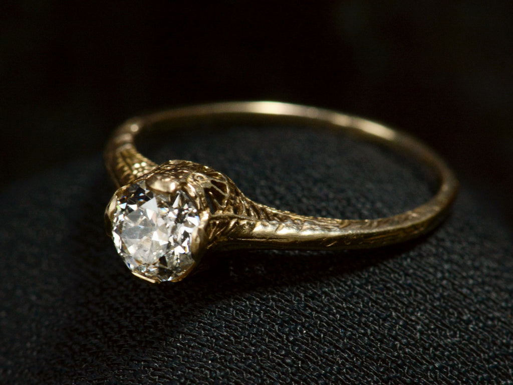 Elevated view of c1920 Art Deco yellow gold engagement ring with a 0.64ct round diamond (on dark background)