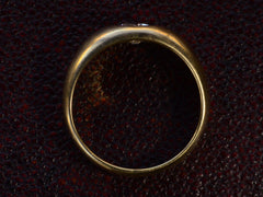 thumbnail of Side profile of a wide rounded antique yellow gold ring with a flush-set old European cut diamond, shown on dark textured background.