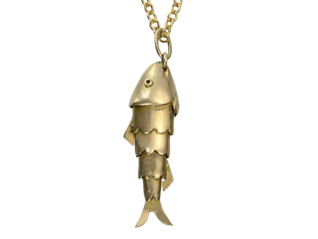 Gold fish-shaped pendant on a chain against a white background