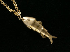 thumbnail of Gold fish-shaped pendant on a chain against a black background