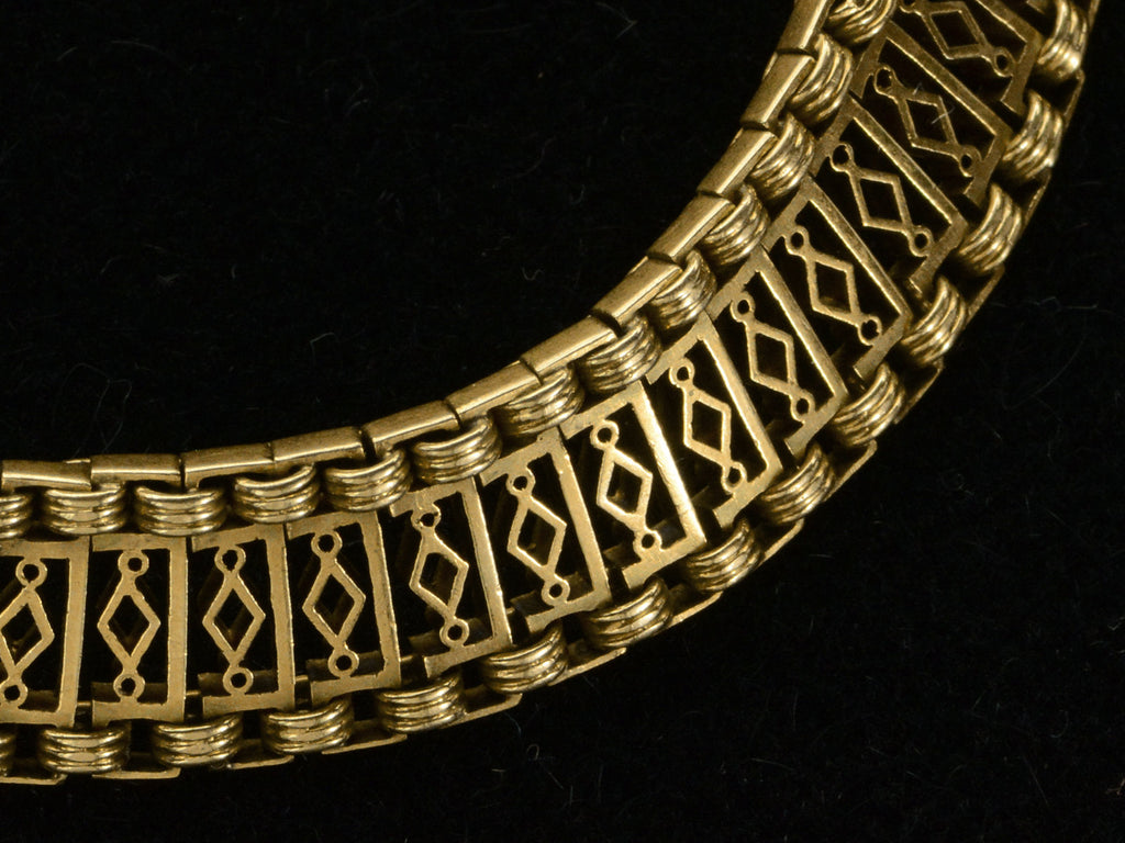 Detail of c1880 French 18K yellow gold bracelet with filigreed links, shown on black background