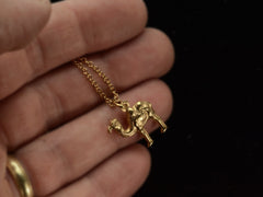 thumbnail of A c1960 18K yellow gold Camel Charm on a cable chain. Shown on hand.