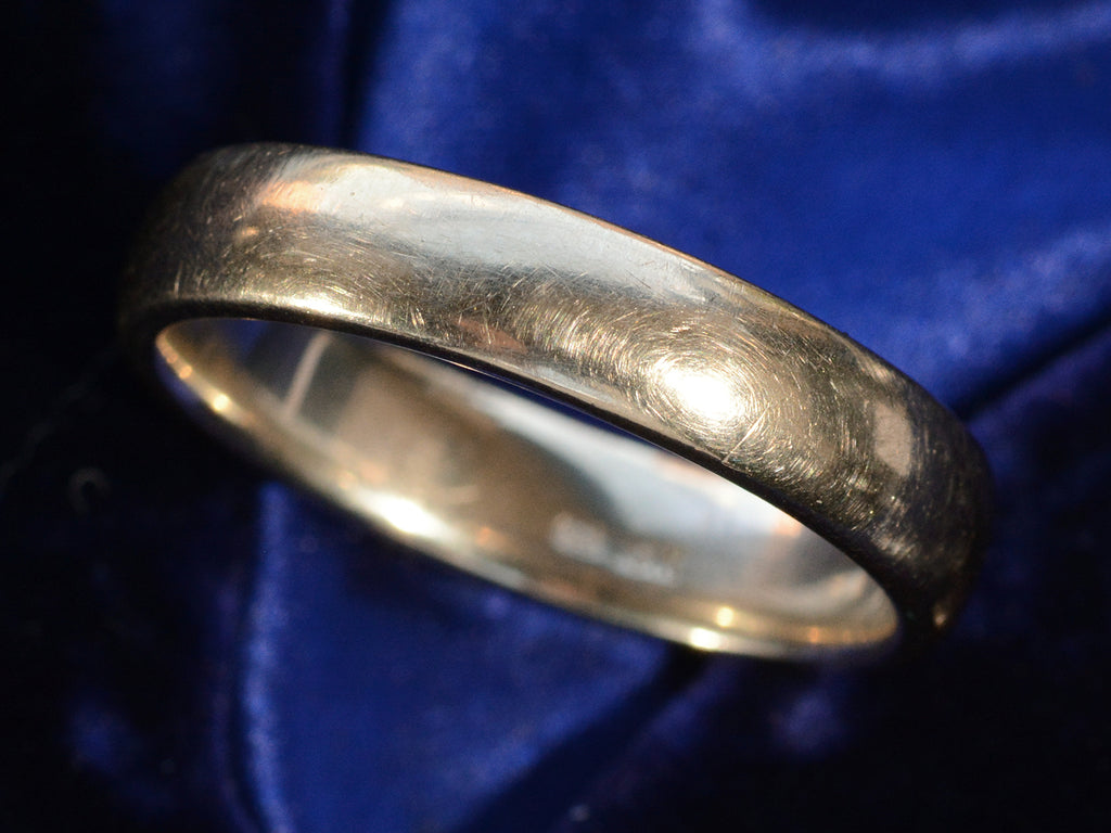 Angled view of c1980 Men's 18K White Gold Wedding Band, on dark blue background