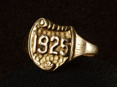 thumbnail of Right front view of Art Deco yellow gold signet ring with the year "1925" on a shield shaped signet face. Shown on dark background.