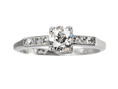 thumbnail of A simple Art Deco platinum engagement ring with a round old cut diamond in four prongs between 3 smaller diamonds on each side, shown on white background.