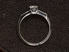 thumbnail of Side profile of simple Art Deco platinum engagement ring on dark textured background.