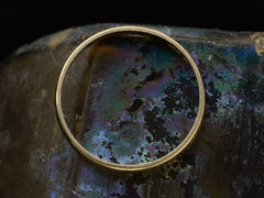 thumbnail of Side profile of a narrow slightly rounded 10k yellow gold band, shown on dark iridescent background.