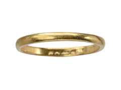 thumbnail of A narrow slightly rounded 22K yellow gold band, shown on white background with indecipherable stamps visible inside band.