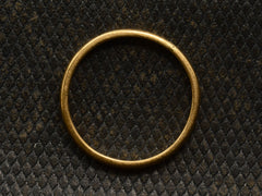 thumbnail of Side profile of a narrow slightly rounded 22K yellow gold band, shown on dark textured background.
