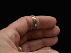 thumbnail of Vintage men's wedding band in yellow gold with center stripes of white gold, shown on finger