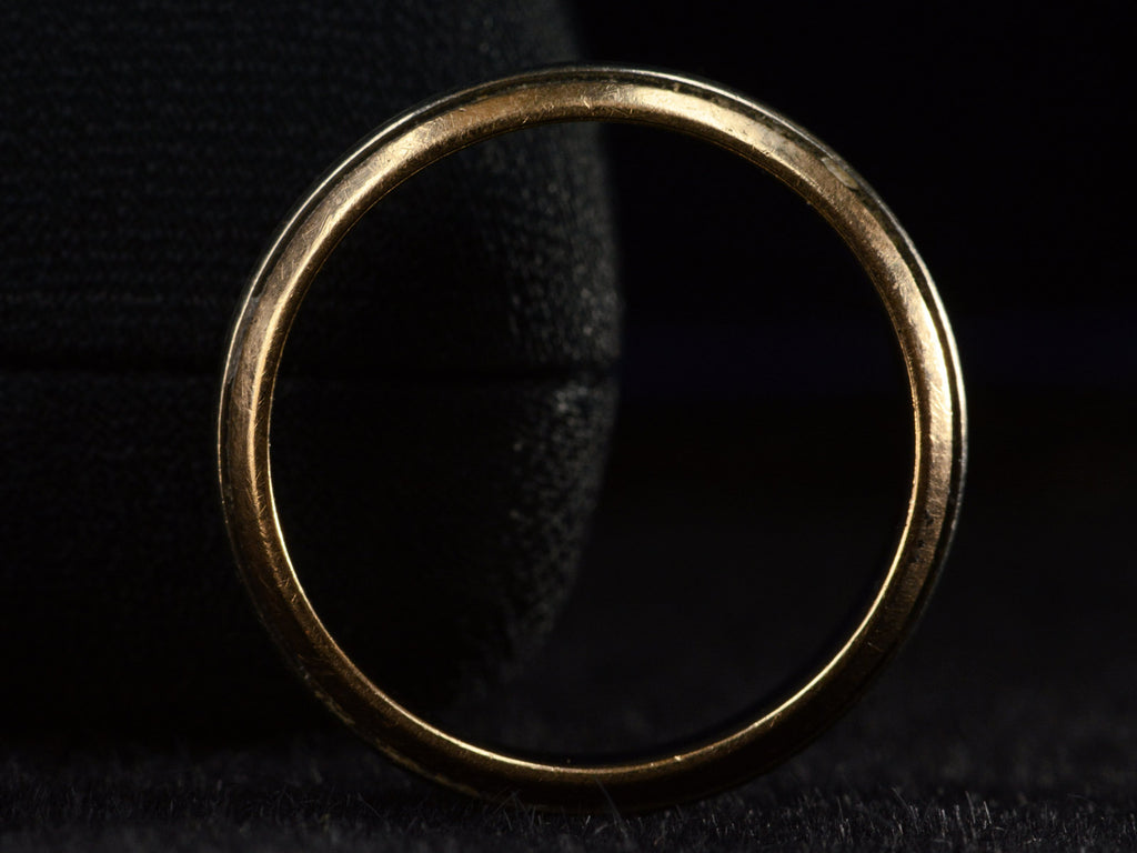 Side profile view of vintage men's wedding band in yellow gold with center stripes of white gold, shown on dark background