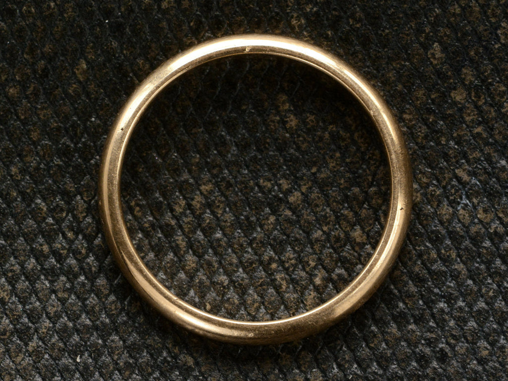 Side profile of a 3.0mm wide rounded 14K yellow gold men's wedding band shown on dark textured background.