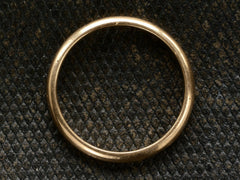 thumbnail of Side profile of a 3.0mm wide rounded 14K yellow gold men's wedding band shown on dark textured background.