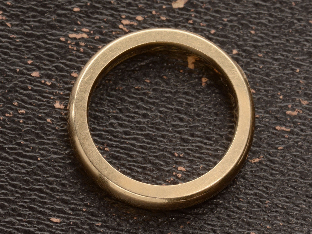 Side profile of a heavy antique wedding band in a rosy-yellow gold measuring 3.2mm wide. Shown on dark background.