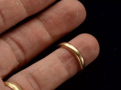 thumbnail of A heavy antique wedding band in a rosy-yellow gold measuring 3.2mm wide. Shown on finger.