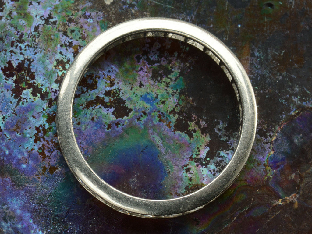 Side profile of c1950 Diamond Eternity Band in Platinum Channel Setting (on colorful background)