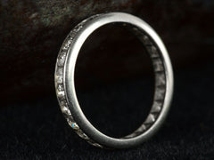 thumbnail of Angled side profile view of c1950 Diamond Eternity Band in Platinum Channel Setting (on dark background)
