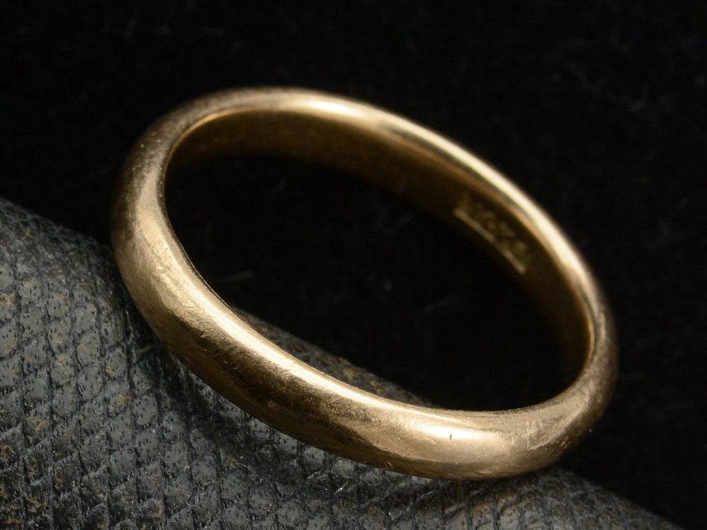 Angled view of an antique rounded rosy-yellow 14k gold wedding band, shown on white background. A "14K" mark is visible inside.