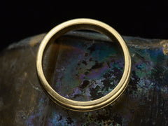 thumbnail of Side profile view of vintage 14k yellow gold wedding band with a groove cut down the middle, shown on dark background.