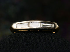 thumbnail of Front view of two toned vintage ring with three diamond baguettes. Shown on dark background.