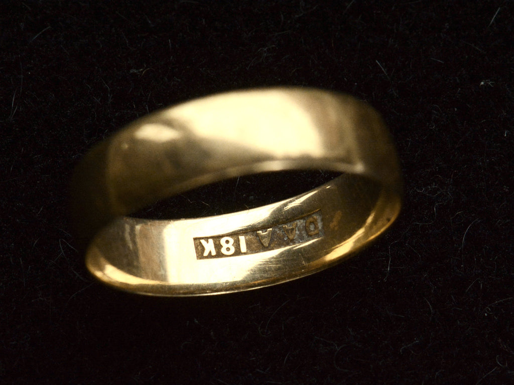 Detail view of wide flat 18K yellow gold antique wedding band, showing inside hallmark reading "DAA 18K"