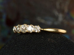 thumbnail of Angled view of antique c1900 ring with five small diamonds set in a row in 18K yellow gold. Shown on dark background.